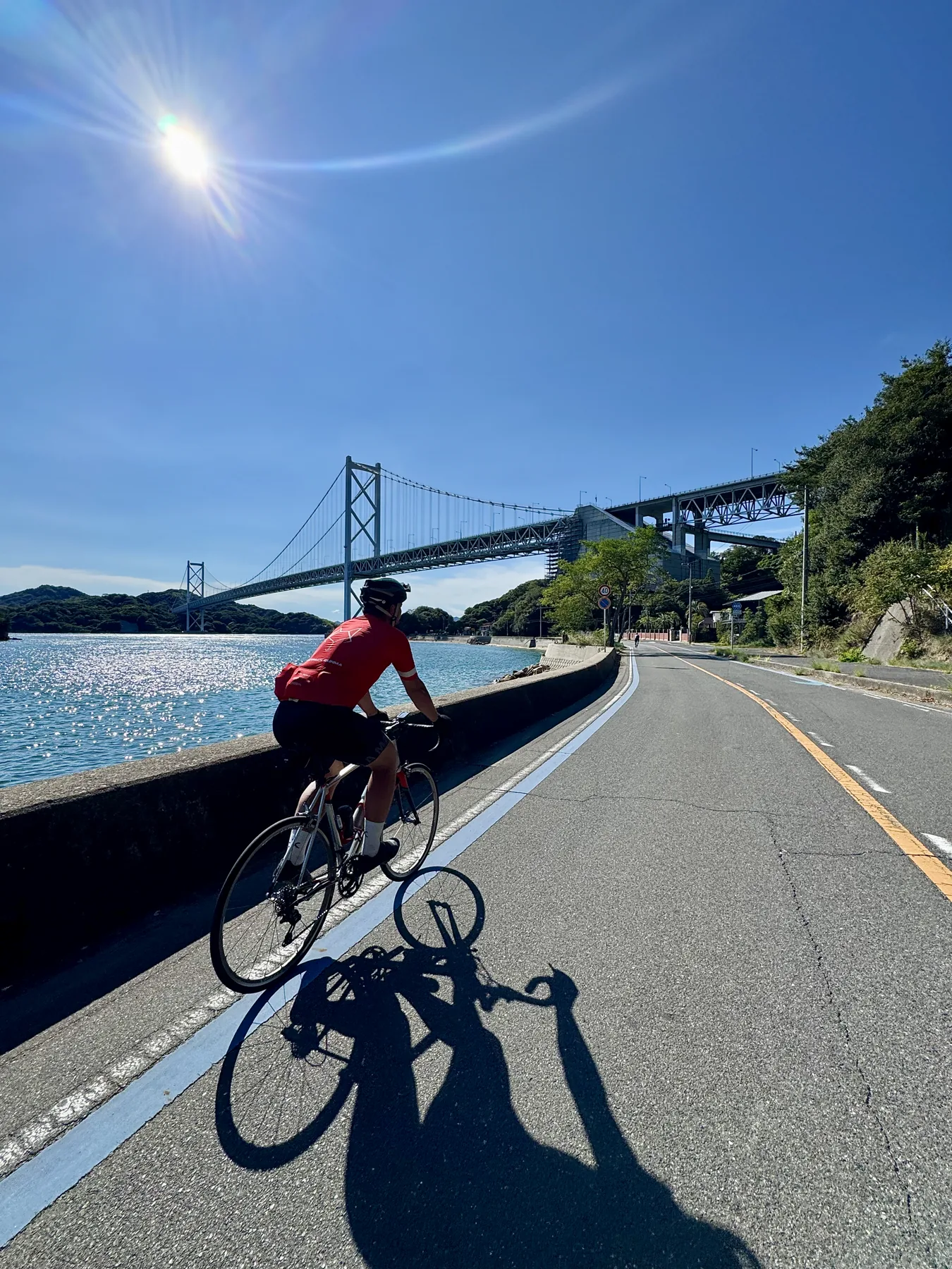 Ciclista avançando pela costa sob o sol